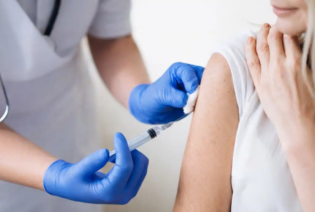 Physician administering an adult vaccination as part of personalized preventive medical care.