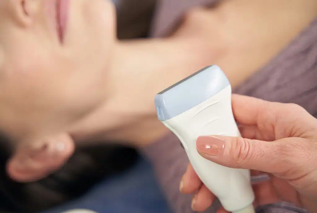 Medical professional performing an at-home ultrasound exam using portable diagnostic imaging equipment
