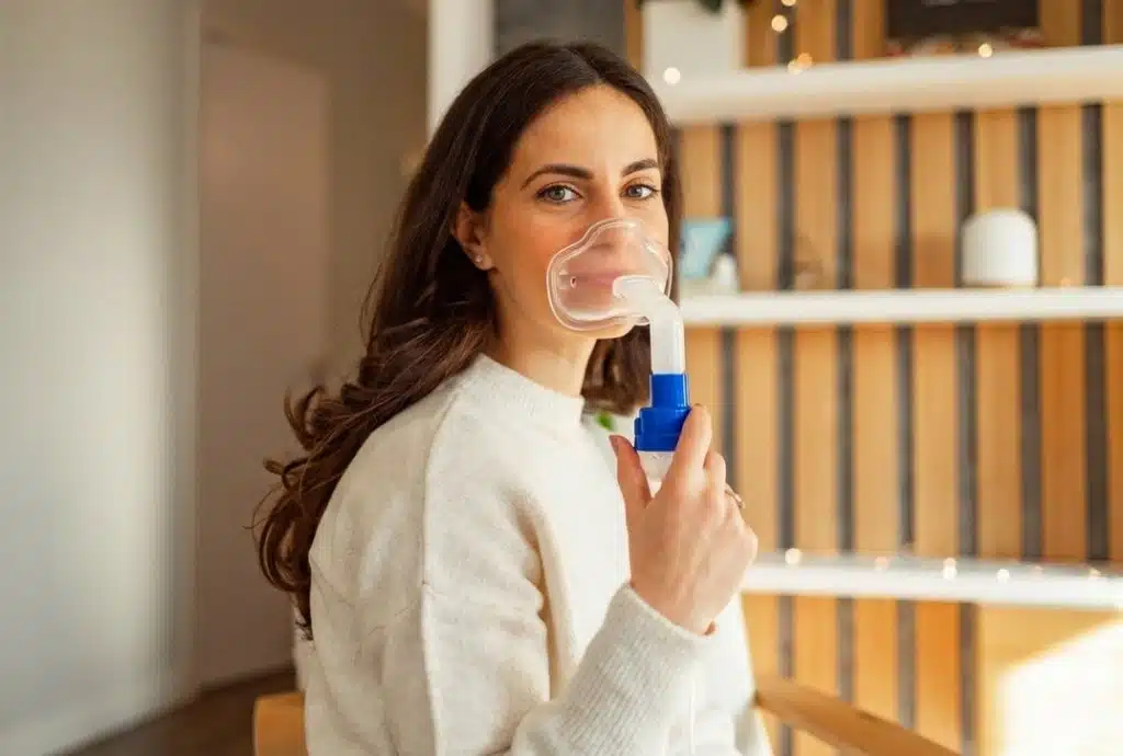 Woman using a nebulizer at home for asthma management